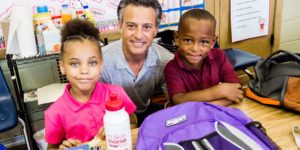 Mike Morse at school taking a picture with two kids for Backpack Project