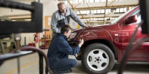 Mechanics working to fix a car that was in an accident